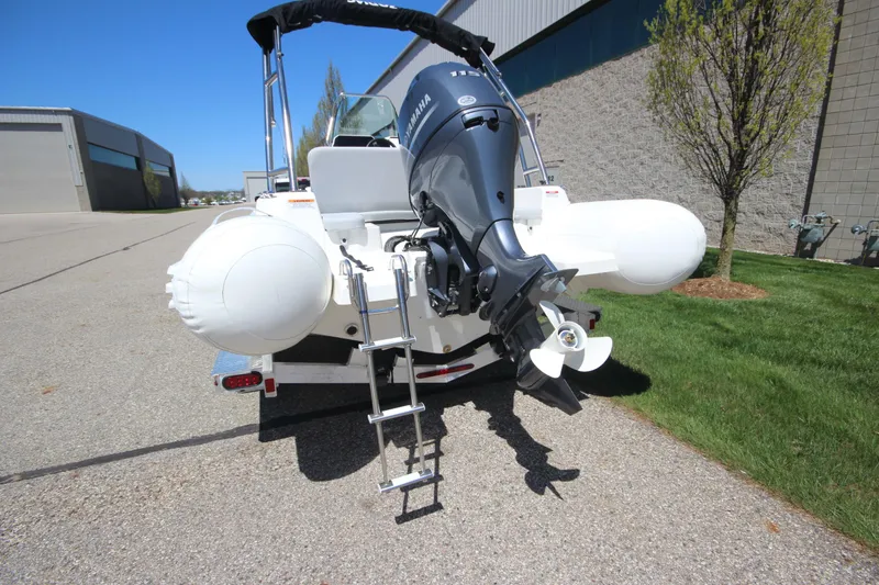 Slide: The Image of 2025 Zodiac Medline 5.8 NEO boat with 115hp engine, parked outdoors. - 4