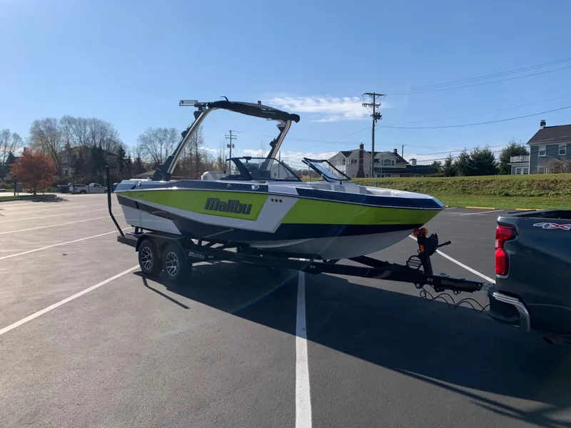 Slide: The Image of 2024 Malibu LX-R boat on trailer in parking lot, attached to a truck. - 11