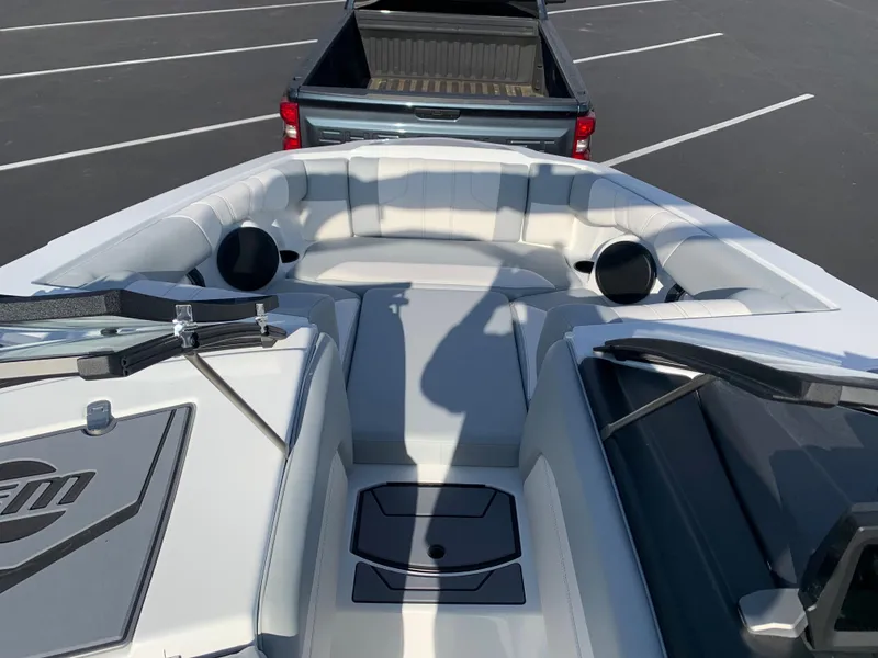 Slide: The Image of 2024 Malibu LX-R boat interior with seating and storage, parked in front of a truck. - 13