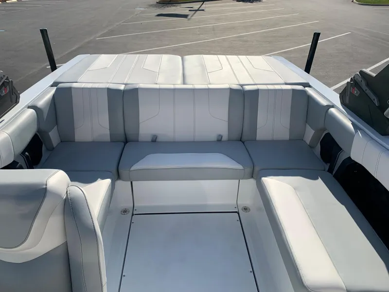 Slide: The Image of 2024 Malibu LX-R boat with spacious, cushioned seating in a parking lot. - 3
