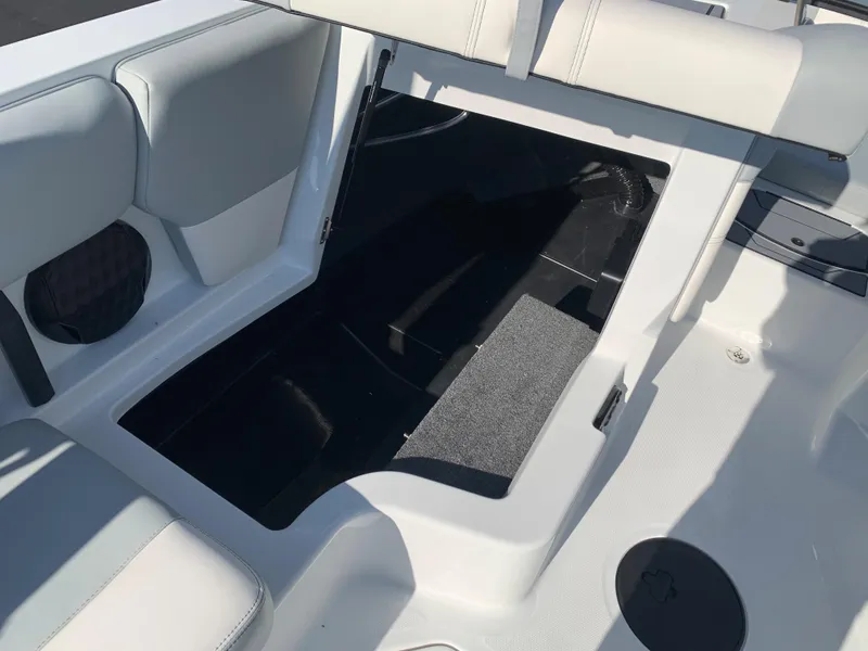 Slide: The Image of 2024 Malibu LX-R boat interior storage compartment with white and gray seating. - 5
