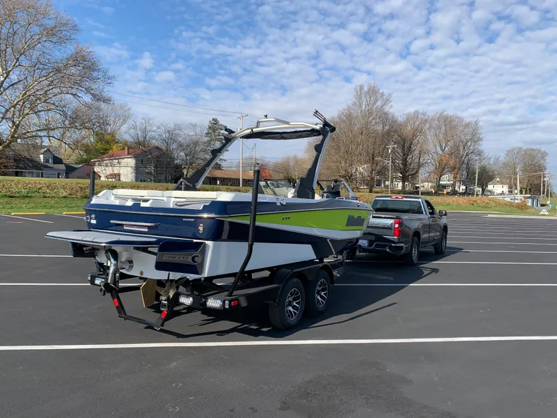 Slide: The Image of 2024 Malibu LX-R boat on trailer, hitched to a truck in a parking lot. - 9