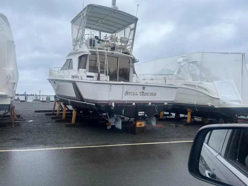 Slide: The Image of 1988 Trojan 12 Meter Convertible boat on stands in a marina storage area. - 21