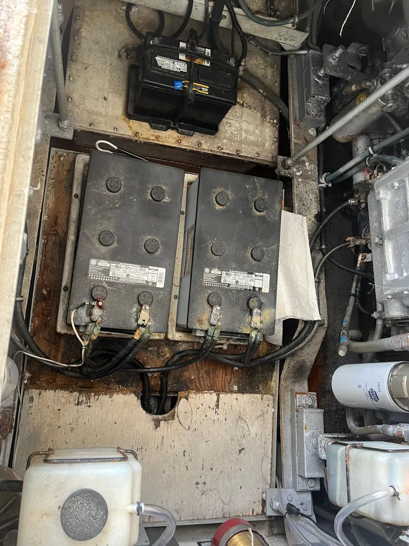 Slide: The Image of 1988 Trojan 12 Meter Convertible engine compartment with batteries and mechanical components. - 23