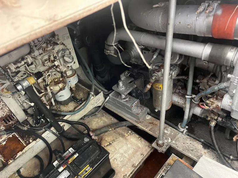 Slide: The Image of Engine compartment of a 1988 Trojan 12 Meter Convertible boat, showing mechanical components. - 25
