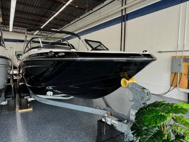 Slide: The Image of 2024 Yamaha Boats SX195 in showroom, sleek black design on trailer. - 1
