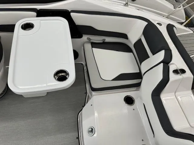 Slide: The Image of 2024 Yamaha Boats SX195 interior with seating and table, featuring cup holders. - 13