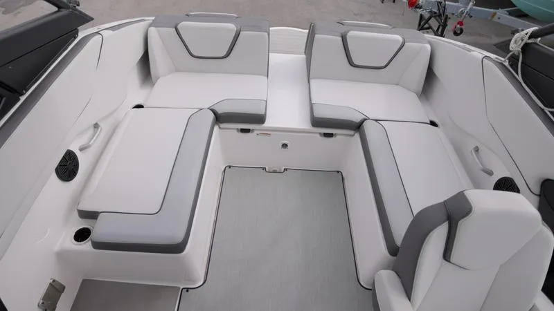 Slide: The Image of 2023 Yamaha Boats AR250 interior seating area with white and gray upholstery. - 12