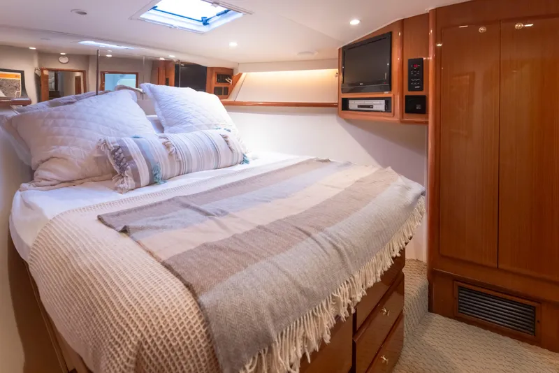 Slide: The Image of Luxurious bedroom interior of 2000 Viking 72 Convertible yacht with cozy bedding. - 24
