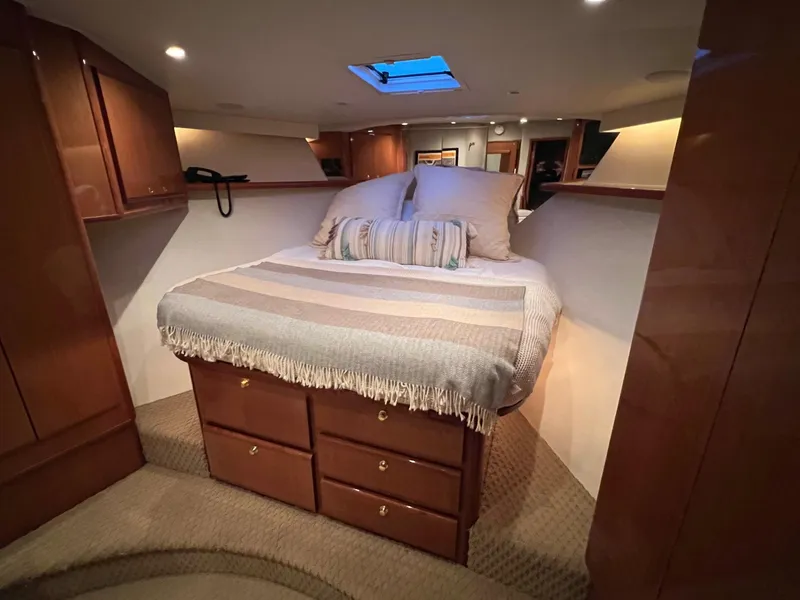Slide: The Image of Cozy bedroom in 2000 Viking 72 Convertible yacht with skylight and wooden cabinetry. - 25
