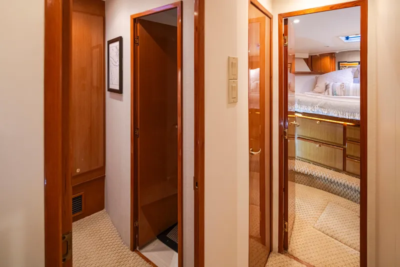 Slide: The Image of Interior hallway of a 2000 Viking 72 Convertible yacht with wooden doors and carpeted floors. - 26