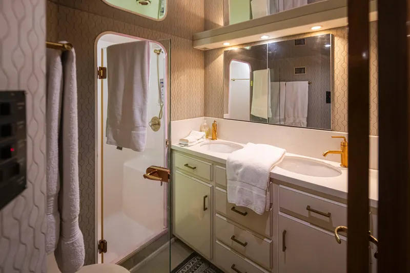 Slide: The Image of Luxurious bathroom in a 2000 Viking 72 Convertible yacht with double sinks and shower. - 29