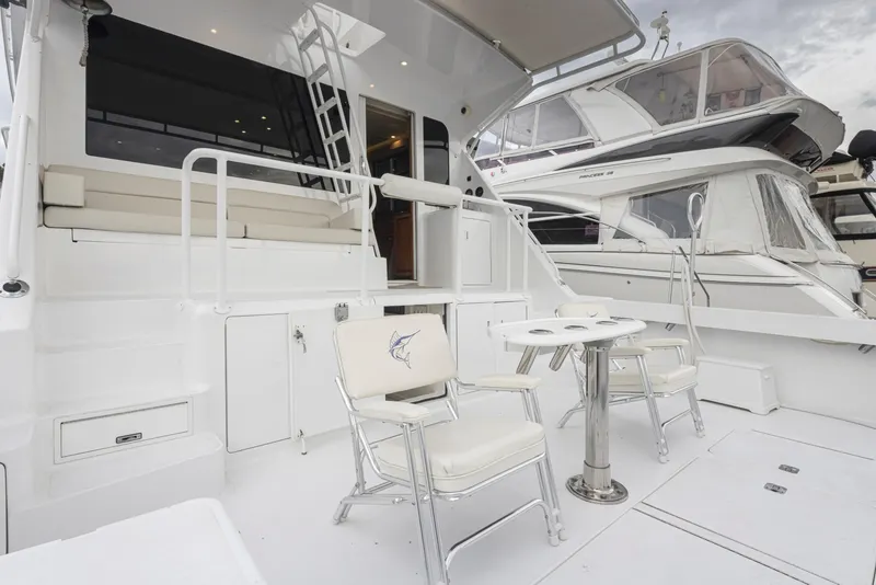 Slide: The Image of Viking 72 Convertible 2000 yacht deck with seating and table, docked beside other boats. - 41