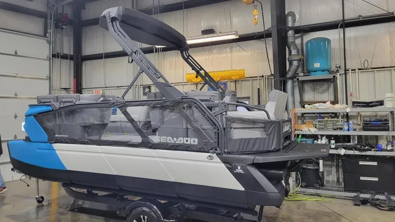 Slide: The Image of 2023 Sea-Doo Switch® Cruise 18-170 hp boat in a workshop. - 0