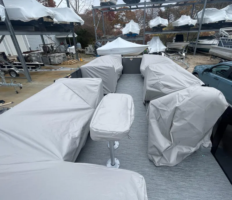 Slide: The Image of 2023 Godfrey Monaco 235 SFL pontoon boat with covered seating, docked in storage area. - 16