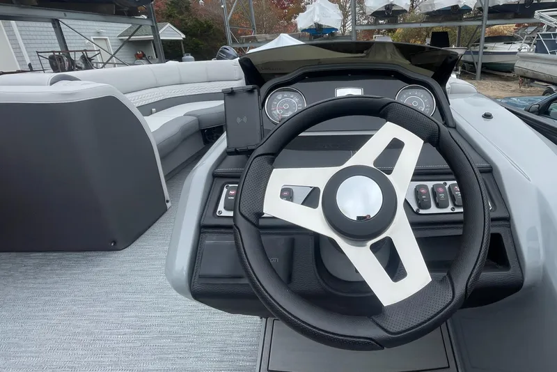Slide: The Image of 2023 Godfrey Monaco 235 SFL boat dashboard with steering wheel and control panel. - 19