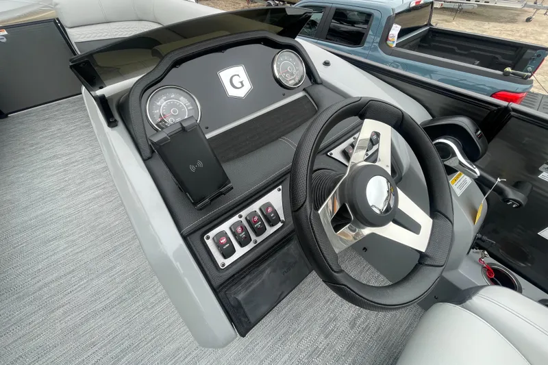 Slide: The Image of 2023 Godfrey Monaco 235 SFL boat dashboard with steering wheel and control panel. - 20