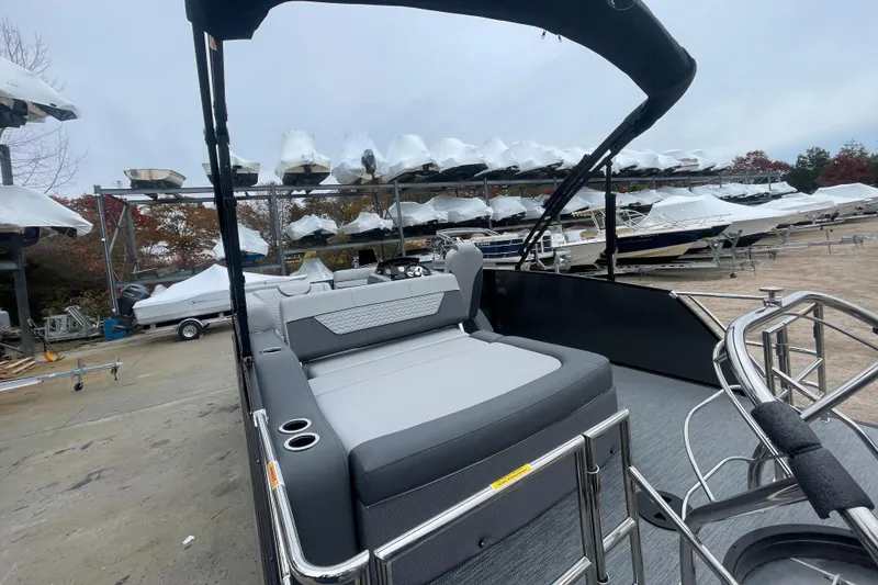 Slide: The Image of 2023 Godfrey Monaco 235 SFL pontoon boat with spacious seating at a marina. - 7