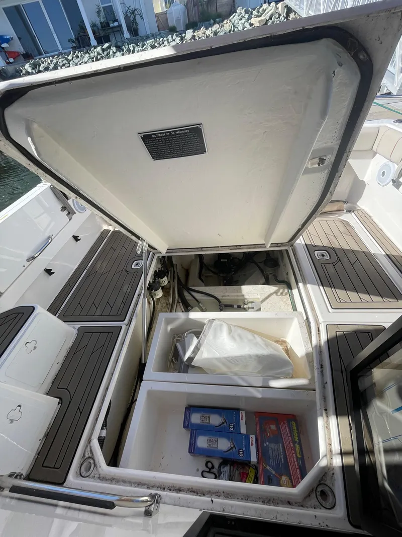 Slide: The Image of 2022 Cutwater Flybridge boat storage compartment with open hatch, revealing organized interior space. - 10