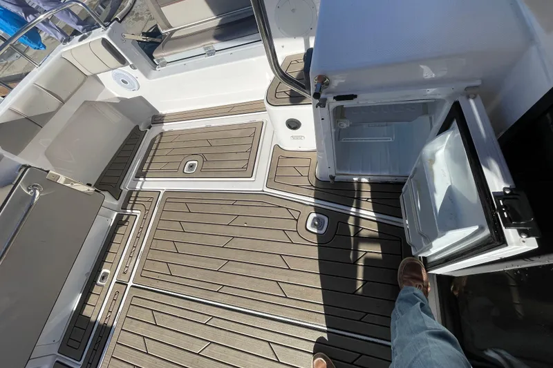 Slide: The Image of 2022 Cutwater Flybridge boat deck with open storage compartment and teak flooring. - 11