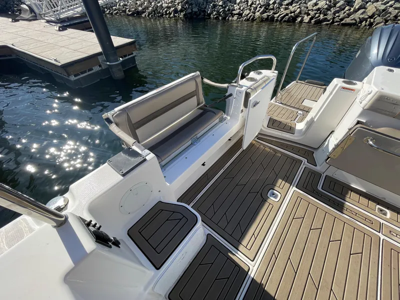 Slide: The Image of 2022 Cutwater Flybridge boat deck with seating, docked by the water. - 15