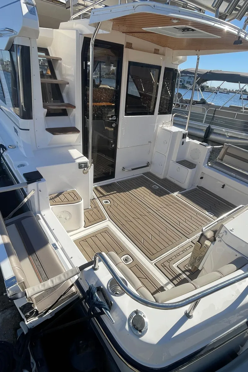 Slide: The Image of 2022 Cutwater Flybridge boat deck with seating, stairs, and wood flooring. - 16