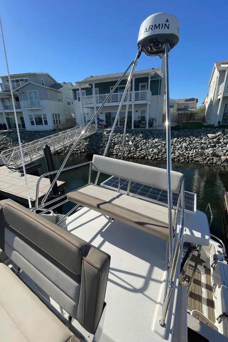 Slide: The Image of 2022 Cutwater Flybridge boat docked near waterfront homes, featuring Garmin equipment. - 21