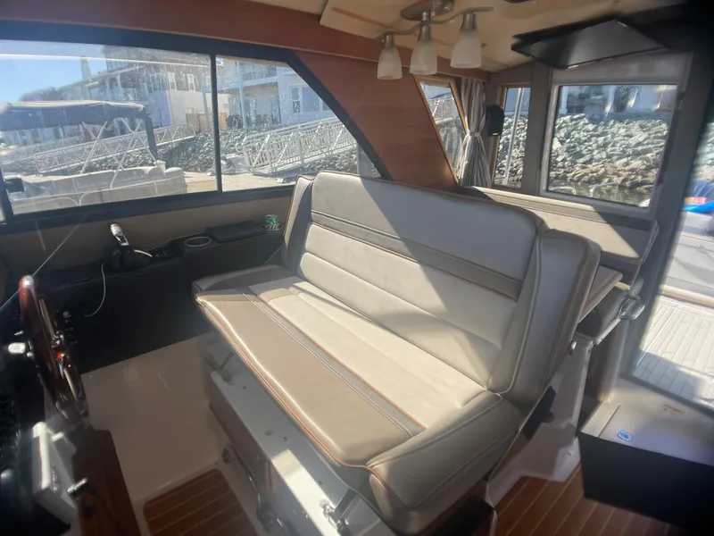 Slide: The Image of 2022 Cutwater Flybridge interior with beige seating and large windows. - 26