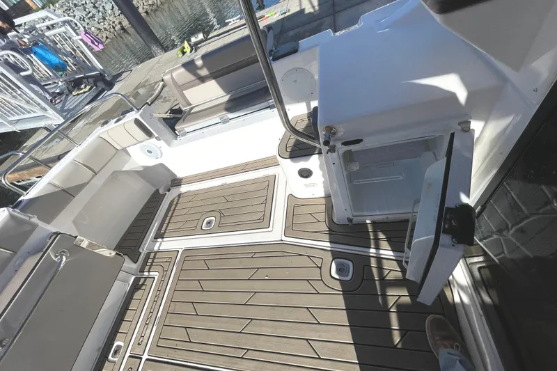 Slide: The Image of 2022 Cutwater Flybridge boat deck with open storage compartment and wood-patterned flooring. - 30