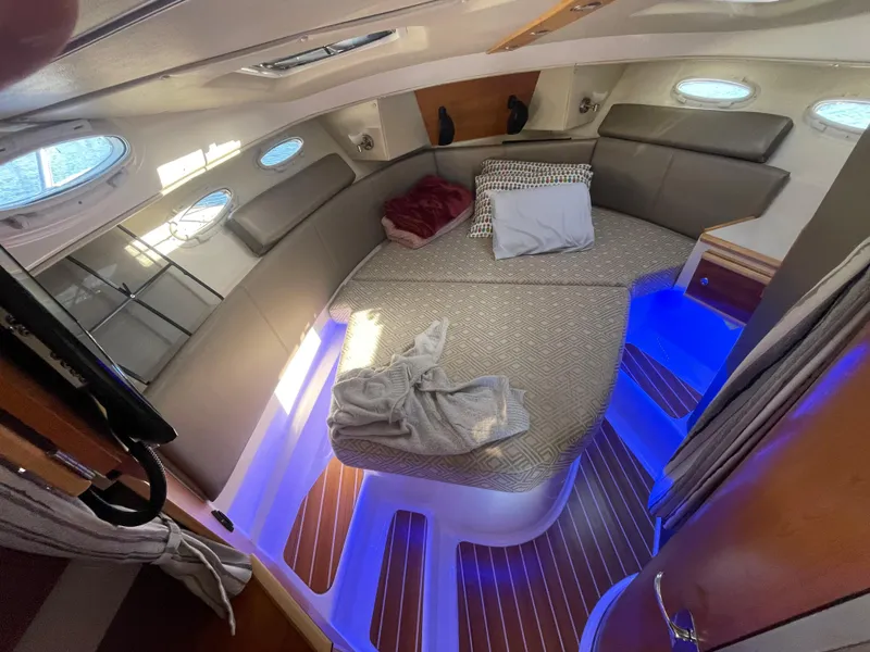 Slide: The Image of 2022 Cutwater Flybridge cabin interior with cozy bedding and ambient blue lighting. - 4