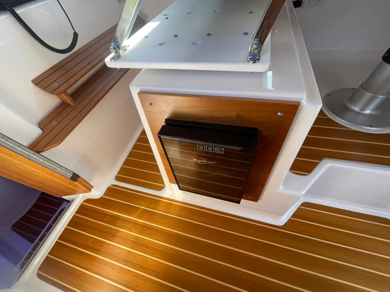 Slide: The Image of 2022 Cutwater Flybridge interior with wood accents and compact fridge. - 5