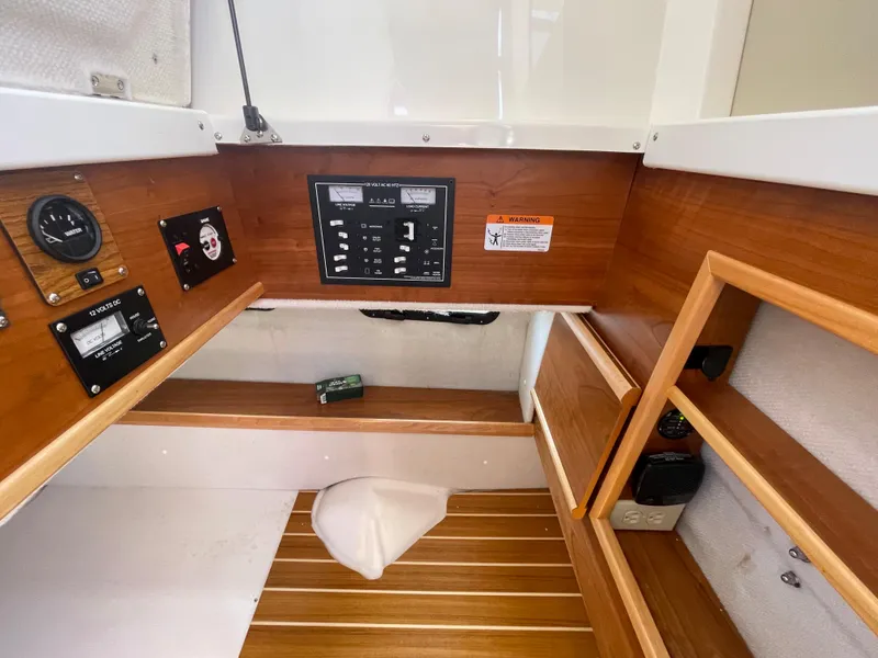 Slide: The Image of 2022 Cutwater Flybridge interior with control panel, wooden cabinetry, and storage space. - 9