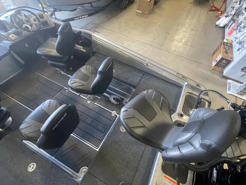 Slide: The Image of 2024 Nitro ZV20 Pro fishing boat interior with four black seats in a showroom. - 8