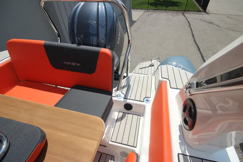 Slide: The Image of 2024 Zodiac Medline 7.5 NEO boat interior with orange seating and wooden table. - 14