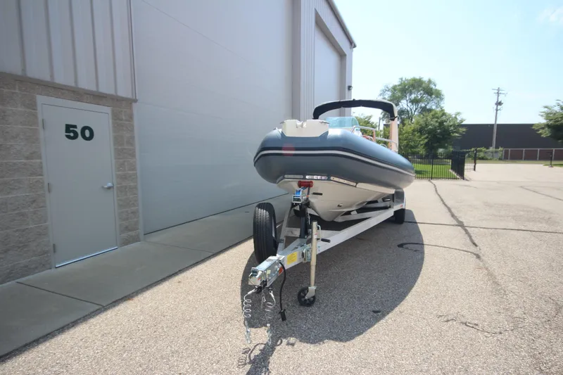 Slide: The Image of 2024 Zodiac Medline 7.5 NEO 300hp boat on trailer outside building. - 2