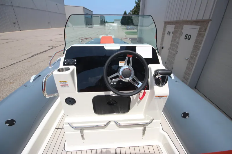 Slide: The Image of 2024 Zodiac Medline 7.5 NEO boat dashboard with steering wheel and controls. - 24