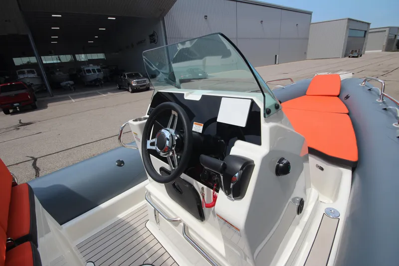 Slide: The Image of 2024 Zodiac Medline 7.5 NEO boat with orange seating and modern dashboard. - 25