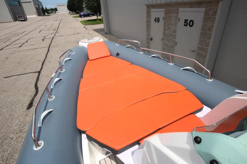 Slide: The Image of 2024 Zodiac Medline 7.5 NEO boat with orange sunbathing deck, docked near storage units. - 28