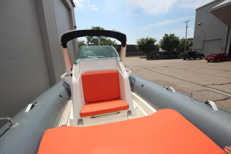 Slide: The Image of 2024 Zodiac Medline 7.5 NEO boat with orange seating, docked outdoors. - 29