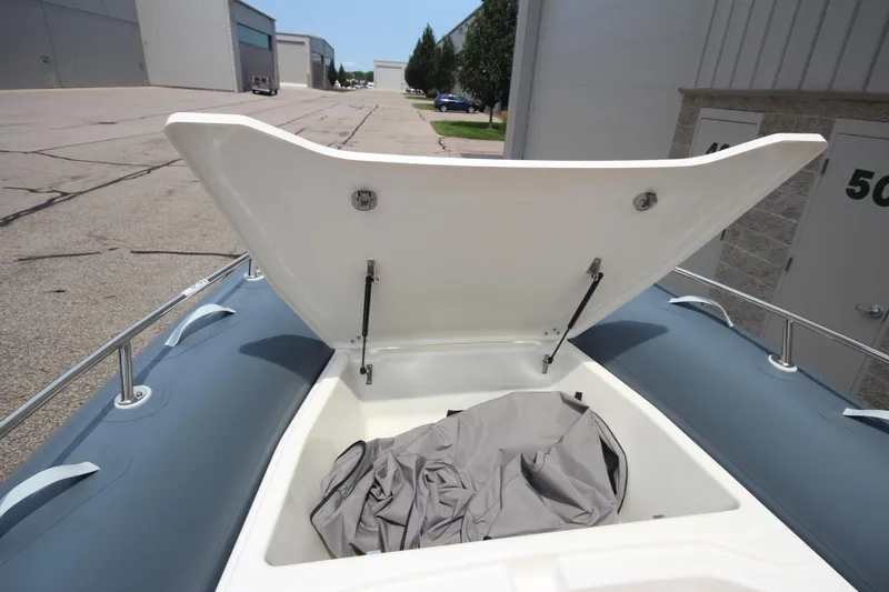 Slide: The Image of 2024 Zodiac Medline 7.5 NEO boat storage compartment open, showing interior space. - 37