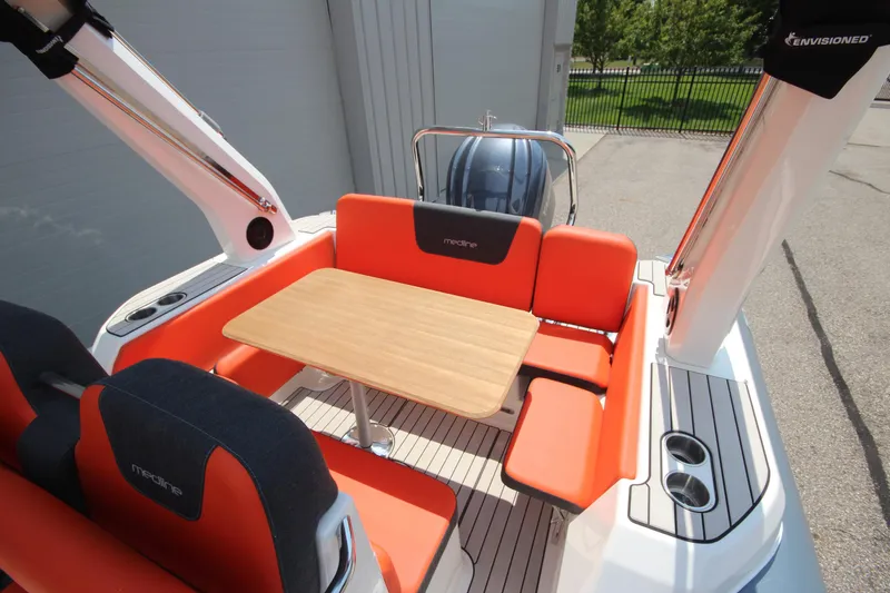 Slide: The Image of 2024 Zodiac Medline 7.5 NEO boat with orange seating and wooden table. - 9