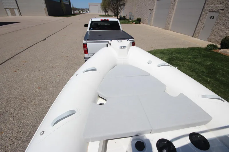 Slide: The Image of 2025 Zodiac Medline 5.8 NEO boat on trailer, parked near industrial buildings. - 19