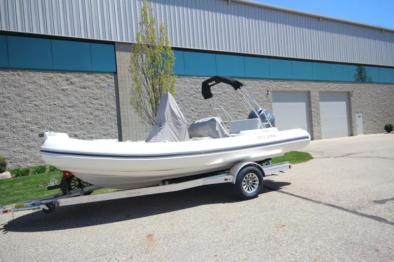 Slide: The Image of 2025 Zodiac Medline 5.8 NEO boat on trailer, parked outside industrial building. - 3
