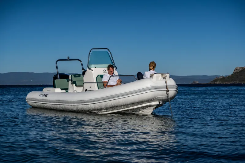 Slide: The Image of 2025 Zodiac Medline 5.8 NEO boat on calm water with two passengers. - 32