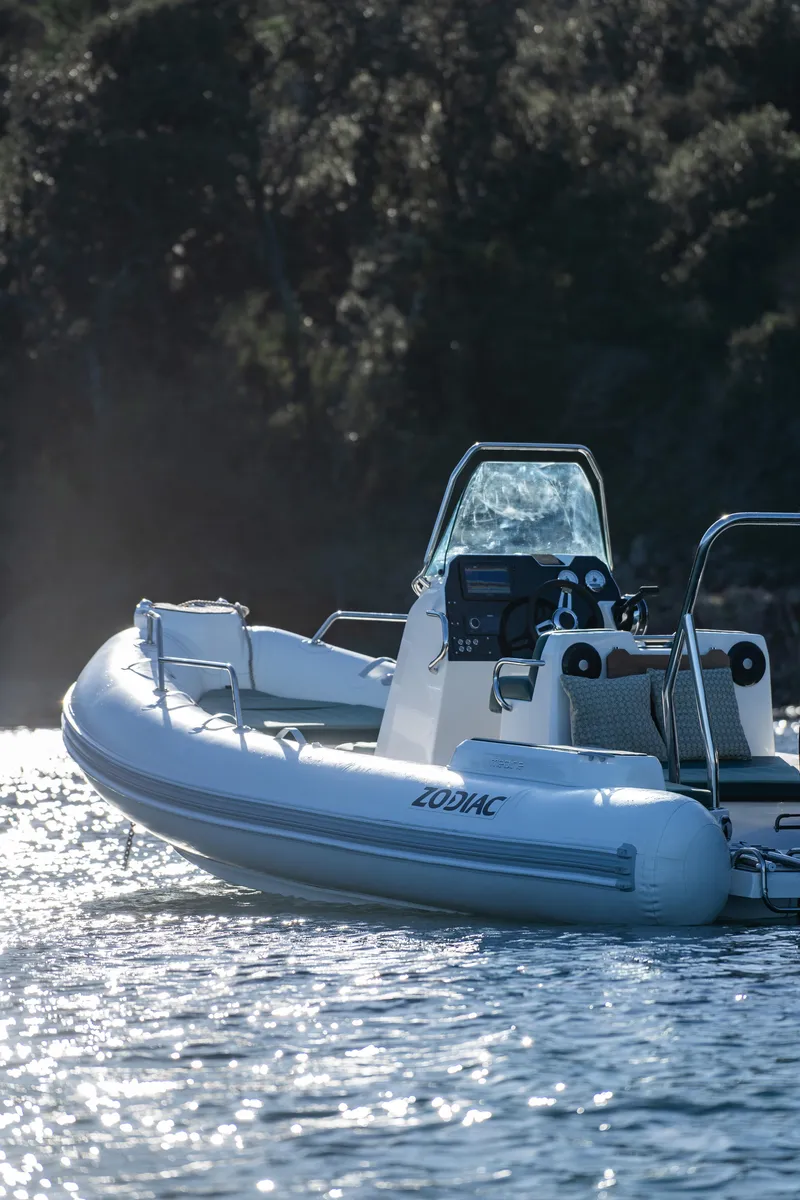 Slide: The Image of 2025 Zodiac Medline 5.8 NEO boat on water, sunlight reflecting, forest background. - 33