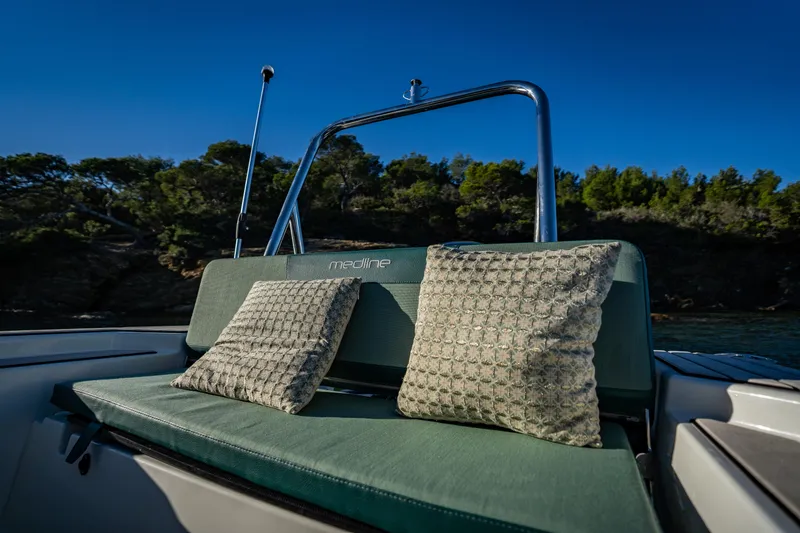 Slide: The Image of 2025 Zodiac Medline 5.8 NEO boat with cushioned seating, scenic backdrop. - 37