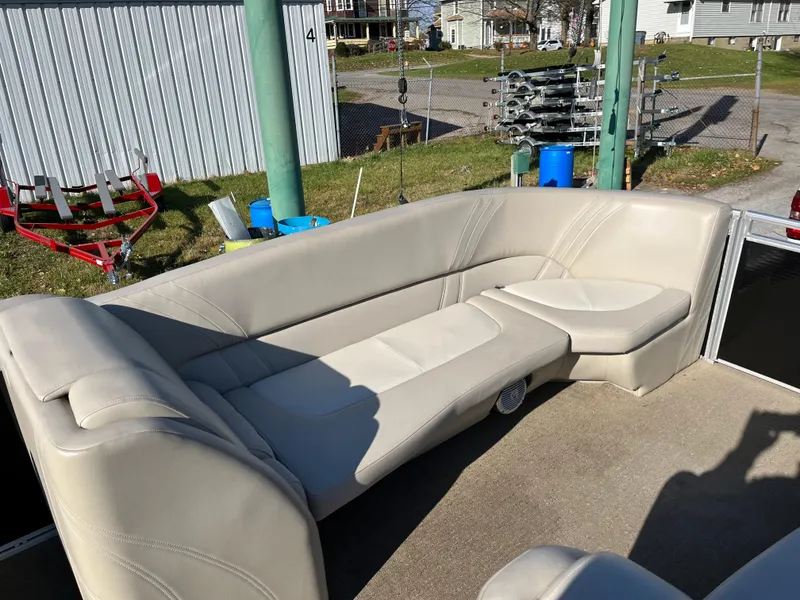 Slide: The Image of 2016 Harris Solstice 240 boat with beige seating in outdoor setting. - 2