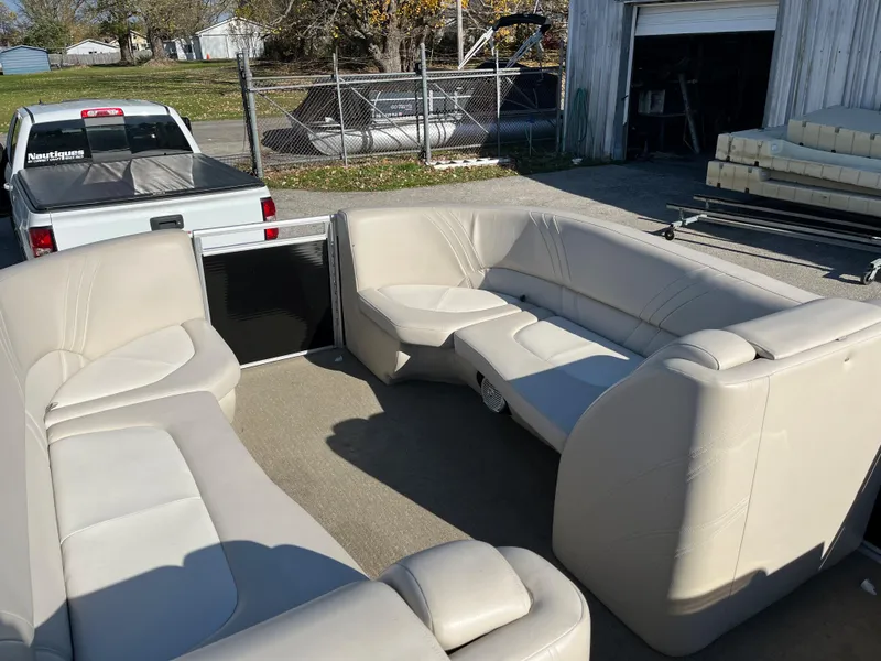 Slide: The Image of 2016 Harris Solstice 240 pontoon boat with beige seating, parked near a white truck. - 3