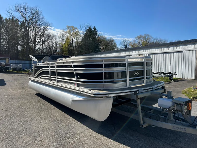 Slide: The Image of 2016 Harris Solstice 240 pontoon boat on a trailer in a parking lot. - 6