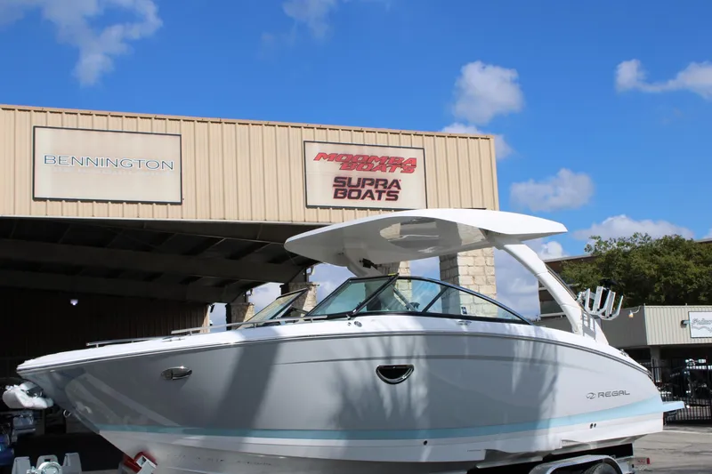 Slide: The Image of 2024 Regal LS9 Surf boat displayed at a dealership. - 2